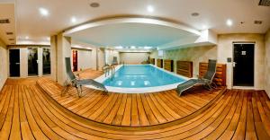 a pool in a large room with a wooden floor at Hotel Mergen Bator in Ulan-Ude