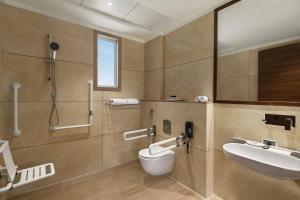 a bathroom with a sink and a toilet and a shower at Ramada by Wyndham Gandhidham Shinay in Gandhidham