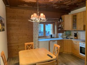 a kitchen with a wooden table and a chandelier at 's Gasthäusl in Kirchberg in Tirol