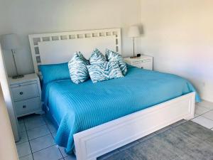 a bedroom with a bed with blue sheets and pillows at Ebb Tide Resort in Pompano Beach