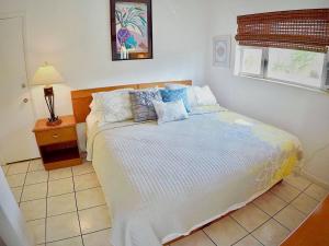 a bedroom with a large white bed with pillows at Ebb Tide Resort in Pompano Beach