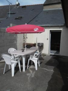 Renac的住宿－gite colorado，一张桌子和两把椅子以及一把红色雨伞