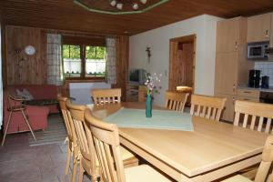 a kitchen and dining room with a wooden table and chairs at Bio-Erlebnisbauernhof Doll in Nittenau