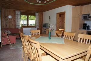 eine Küche und ein Esszimmer mit einem Holztisch und Stühlen in der Unterkunft Bio-Erlebnisbauernhof Doll in Nittenau