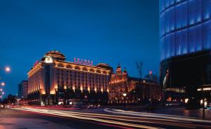 uma rua da cidade com edifícios à noite com faixas de luzes em Sunworld Dynasty Hotel Beijing Wangfujing em Pequim