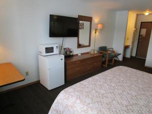 Una habitación de hotel con dos camas y un televisor de pantalla plana. en Dakota Country Inn, en Platte