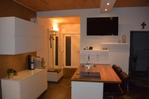 a kitchen with a table and a tv on the wall at Mostviertel Lodge in Ardagger Markt