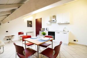 eine Küche und ein Esszimmer mit einem Tisch und Stühlen in der Unterkunft V12 Apartments - Vittoria 12 in Novara
