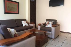 a living room with two couches and a coffee table at Confortable mini departamento in Loja