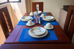 un tavolo in legno con piatti e piattini di Confortable mini departamento a Loja