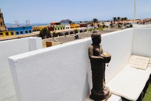 una estatua de una mujer sosteniendo una vela en un balcón en Villa Beach Club, en Corralejo