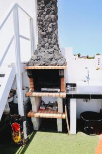 una chimenea de piedra en el lateral de una casa en Villa Beach Club, en Corralejo
