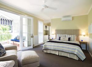 a large bedroom with a bed and a couch at Bells at Killcare Boutique Hotel, Restaurant & Spa in Killcare +80 photos