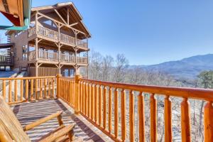 a large wooden deck on a house with a balcony at Papa Bears Cabin in Gatlinburg