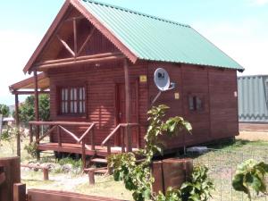 a small wooden house with a green roof at Cabañas El Caribe - Martinica in San Luis