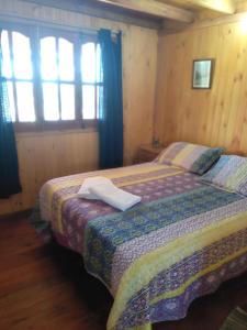 ein Schlafzimmer mit einem Bett in einem Zimmer mit Fenstern in der Unterkunft Cabañas El Caribe - Martinica in San Luis