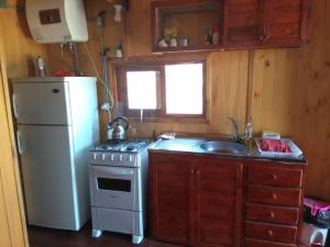a kitchen with a refrigerator and a stove and a sink at Cabañas El Caribe - Martinica in San Luis