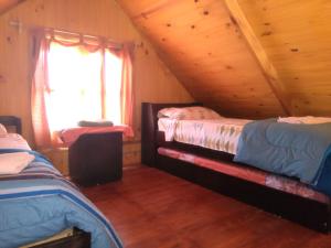 1 Schlafzimmer mit 2 Betten in einer Holzhütte in der Unterkunft Cabañas El Caribe - Martinica in San Luis