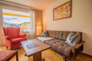 a living room with a couch and a chair and a table at Rothornblick 46 by Arosa Holiday in Arosa