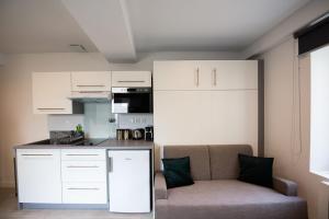 a living room with a couch and a kitchen at Studio Saint Louis - Cosy & Design in Lyon
