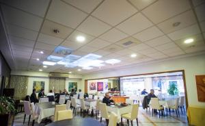a restaurant with people sitting at tables in a room at Hotel Garden in Rosario