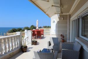 Un patio con sillas y una mesa en el balcón. en Villa Dimitri - Penthouse Seaview, en Alexandroupoli