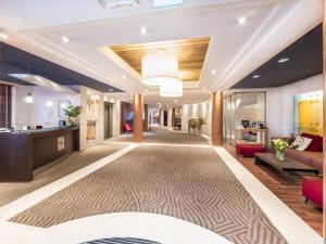 a lobby of an office building with a carpet at Hôtel Le Pré Carré in Annecy
