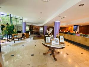 a lobby with a table with pictures on it at Hotel Garden in Rosario