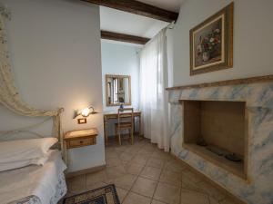 1 dormitorio con chimenea, 1 cama y 1 mesa en Agriturismo Forzello, en Ariano nel Polesine