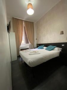 una camera da letto con un letto con lenzuola bianche e una finestra di The Place In Rome Guest House a Roma