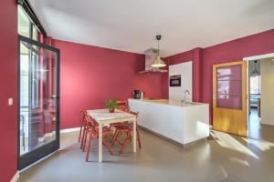 cocina con paredes rojas, mesa y sillas en Apartment with Rooftop Terrace in the Heart of Antwerp, en Amberes