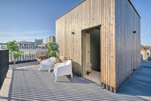 un edificio de madera con 2 sillas blancas en el balcón en Apartment with Rooftop Terrace in the Heart of Antwerp, en Amberes