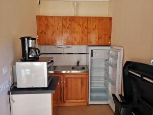 a small kitchen with a sink and a refrigerator at Les Gîtes du Val in Valprivas +13 photos