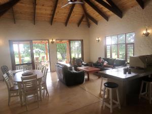 ein Wohnzimmer mit einer Person auf einer Couch in der Unterkunft Mkhiweni Villa at Dombeya Wildlife Estate in Mbabane