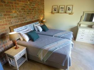 two beds in a bedroom with a brick wall at Mkhiweni Villa at Dombeya Wildlife Estate in Mbabane