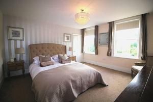 a bedroom with a large bed and two windows at Sterling House @ Short Stays in Basingstoke