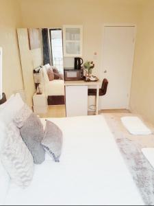 a bedroom with a white bed and a living room at The 55 in Enfield
