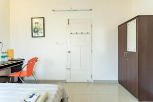 a bedroom with a bed and a desk and a closet at The Pod Cochin Homestay in Cochin