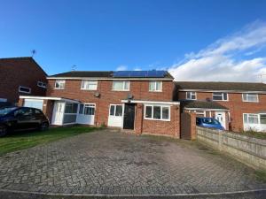 une maison en briques avec des panneaux solaires sur le toit dans l'établissement Lovely Homes, à Aylesbury