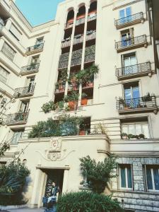 un homme debout devant un grand bâtiment dans l'établissement Le Palladium quartier Tzaréwitch Nice, à Nice
