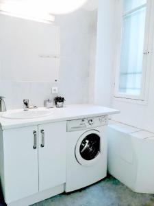 - une cuisine blanche avec un lave-linge et un évier dans l'établissement Le Palladium quartier Tzaréwitch Nice, à Nice