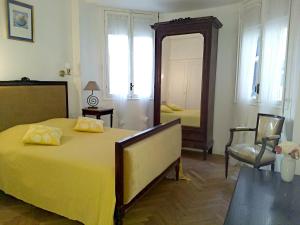 - une chambre avec un grand lit jaune et un miroir dans l'établissement Le Palladium quartier Tzaréwitch Nice, à Nice