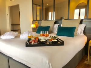 a large white bed with a tray of food on it at Hôtel de la Plage - Saint Jean de Luz in Saint-Jean-de-Luz