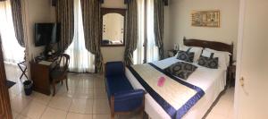 una camera con un letto, una sedia blu e una TV di Hotel Villa Savoia a Torino
