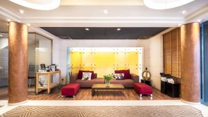 a living room with a couch and red chairs at H&ocirc;tel Le Pr&eacute; Carr&eacute; in Annecy