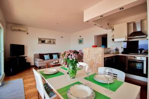 a kitchen and living room with a table and chairs at Sandy Beach Apartments in Duće