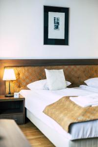 dwa łóżka w pokoju hotelowym z lampką na stole w obiekcie Pension Gallery w Braszowie