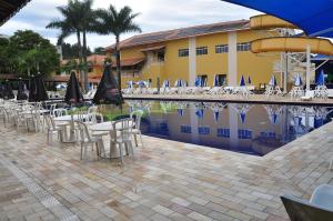 a group of chairs and umbrellas next to a pool at Resort Recanto do Teixeira All Inclusive in Nazaré Paulista