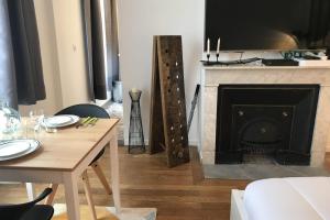a living room with a table and a fireplace at Le Joyau de Jouhaux appartement G - Lyon Garibaldi in Lyon