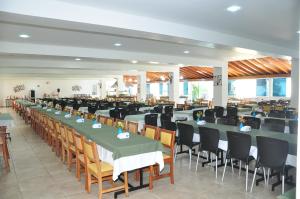 um salão de banquetes com mesas e cadeiras longas em Resort Recanto do Teixeira All Inclusive em Nazaré Paulista